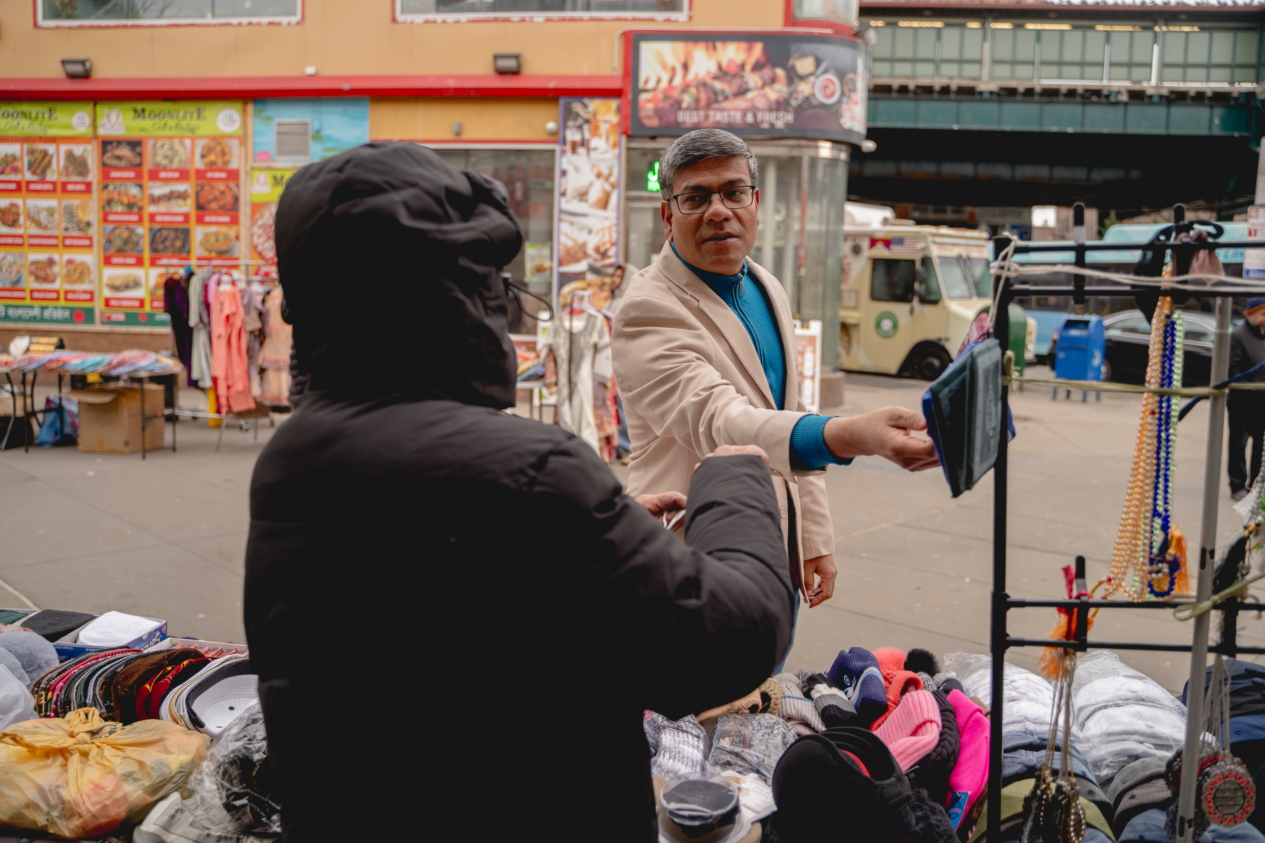 Shamsul Haque greeting a vendor in the Jackson Heights market